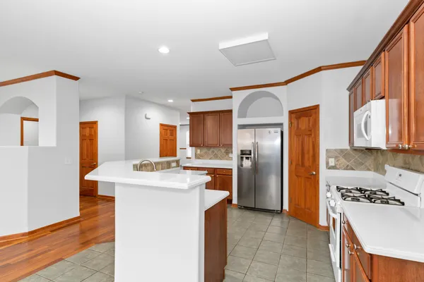 a kitchen with stainless steel appliances granite countertop a refrigerator a stove and a sink