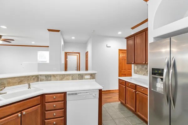 a kitchen with stainless steel appliances granite countertop a sink and a refrigerator