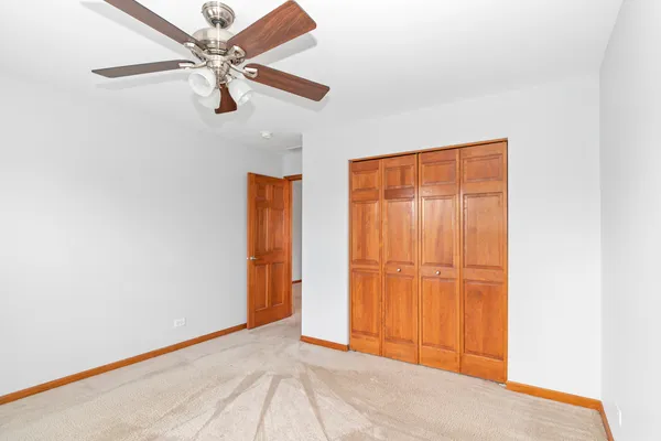 a view of a room with wooden floor and a ceiling fan