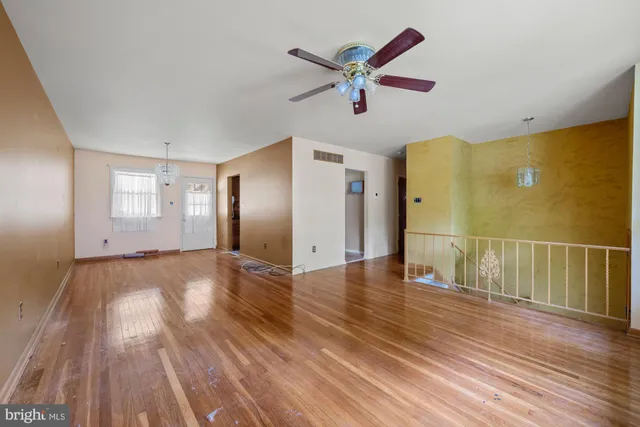 a view of a livingroom with wooden floor and a ceiling fan