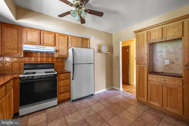 a kitchen with a refrigerator and a stove top oven