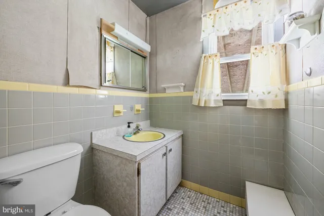 a bathroom with a sink a toilet and a mirror