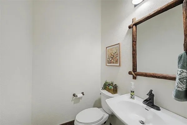a bathroom with a sink mirror and toilet