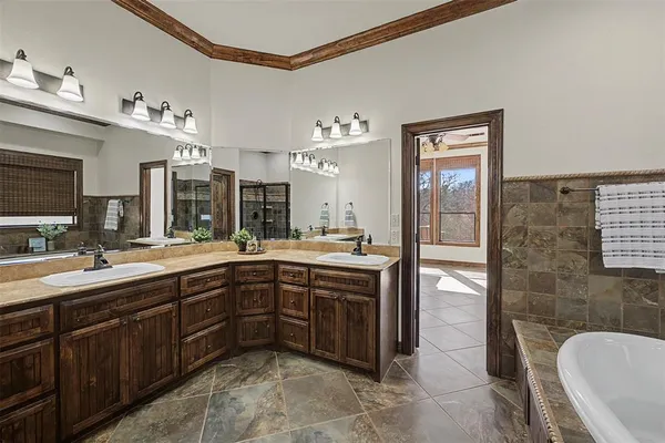 a spacious bathroom with a tub sink shower and mirror