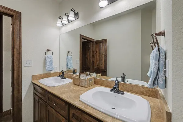 a bathroom with double vanity sinks and a mirror