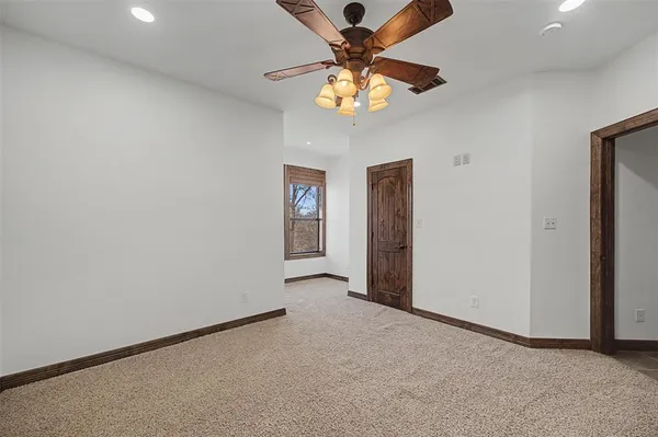 an empty room with chandelier fan