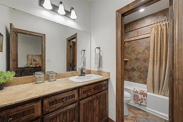 a bathroom with a granite countertop sink a mirror and a shower