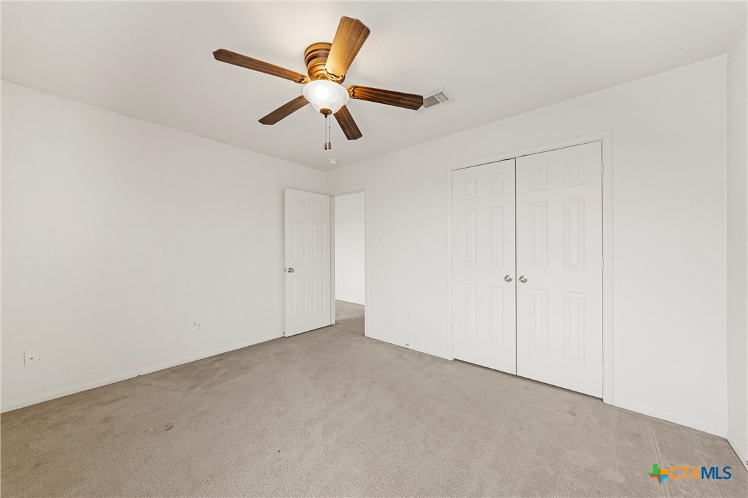 2209 Riley Drive Killeen, TX 76542 - Photo 27 of 33 an empty room with a chandelier fan and a ceiling fan
