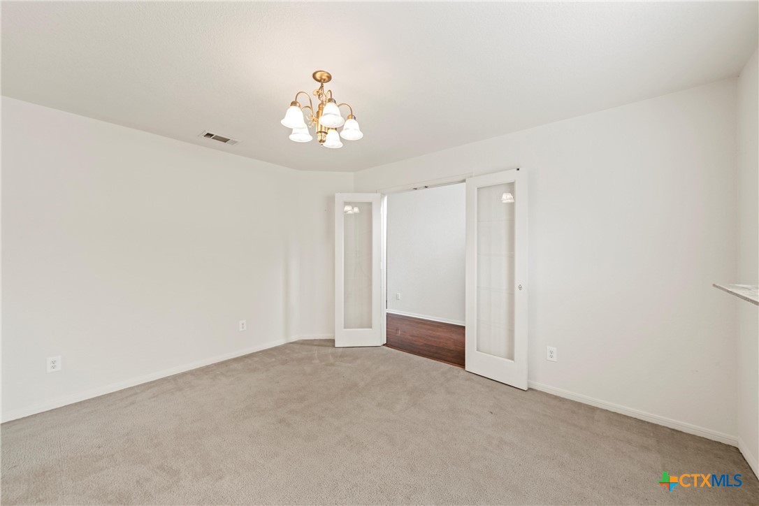 2209 Riley Drive Killeen, TX 76542 - Photo 7 of 33 an empty room with a chandelier fan and windows
