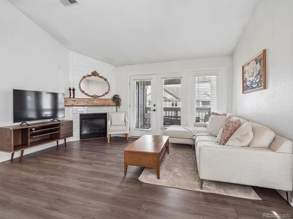 a living room with furniture a flat screen tv and a fireplace