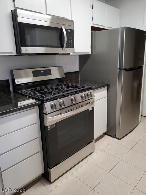 7885 West Flamingo Road, Unit 1064 Las Vegas, NV 89147 - Photo 4 of 19 Kitchen with stainless steel appliances, white cabinetry, and light tile patterned floors