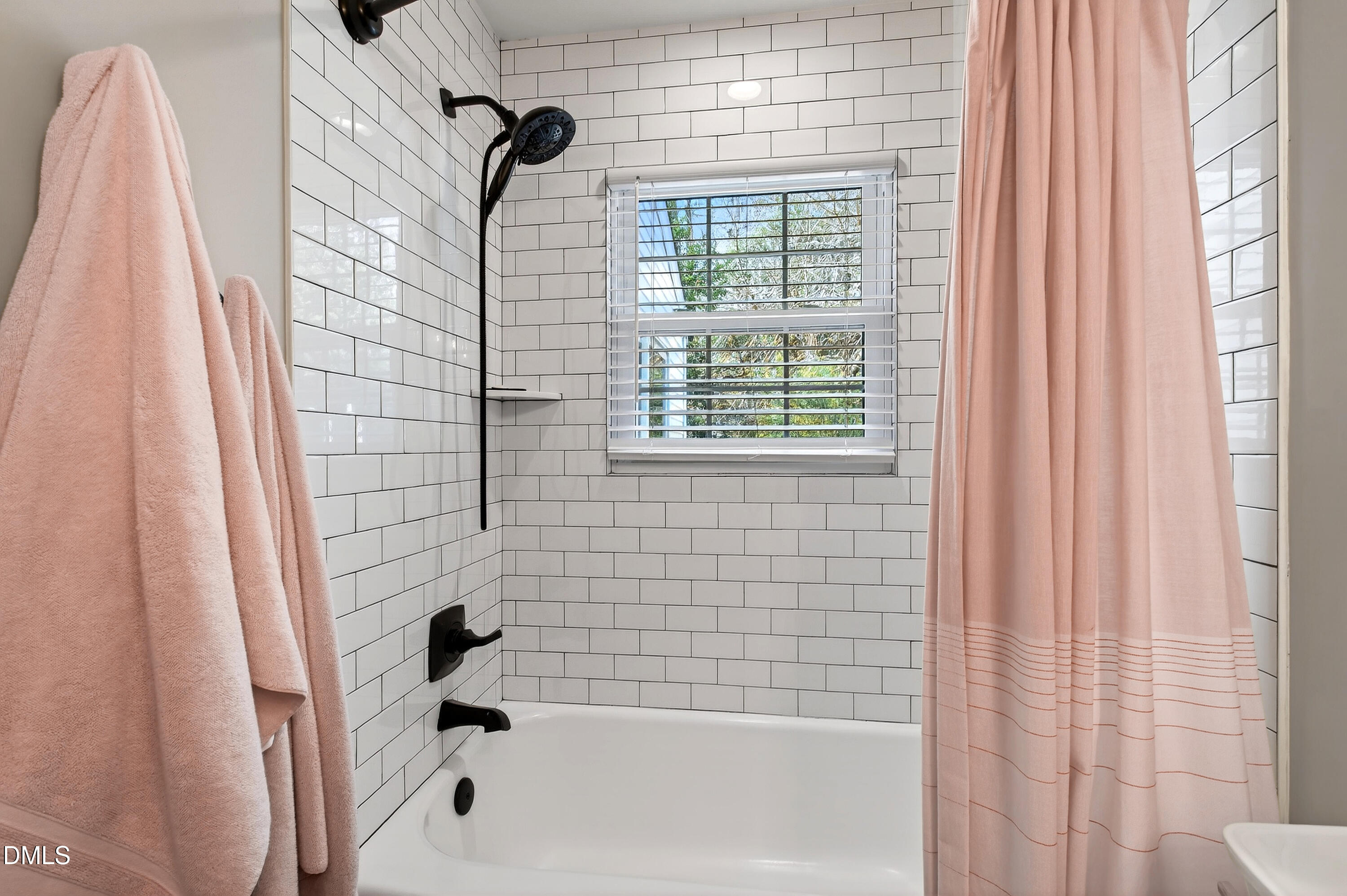 605 Chatham Lane Raleigh, NC 27610 - Photo 30 of 40 a bathroom with a bathtub a shower and a window