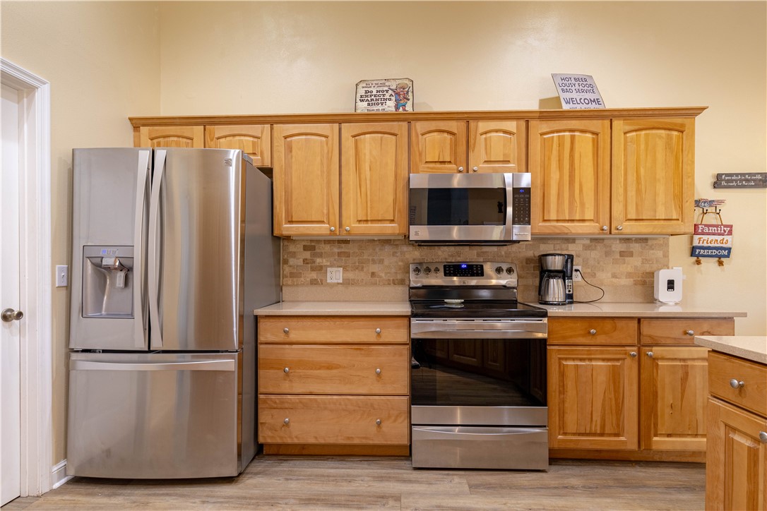 152 35th Square Southwest Vero Beach, FL 32968 - Photo 14 of 35 a kitchen with stainless steel appliances granite countertop a refrigerator stove and sink with wooden floor
