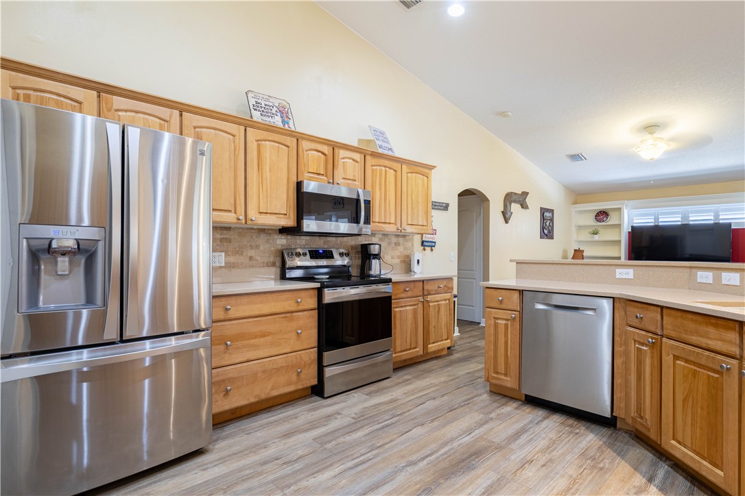 152 35th Square Southwest Vero Beach, FL 32968 - Photo 16 of 35 a kitchen with stainless steel appliances white cabinets and wooden floor