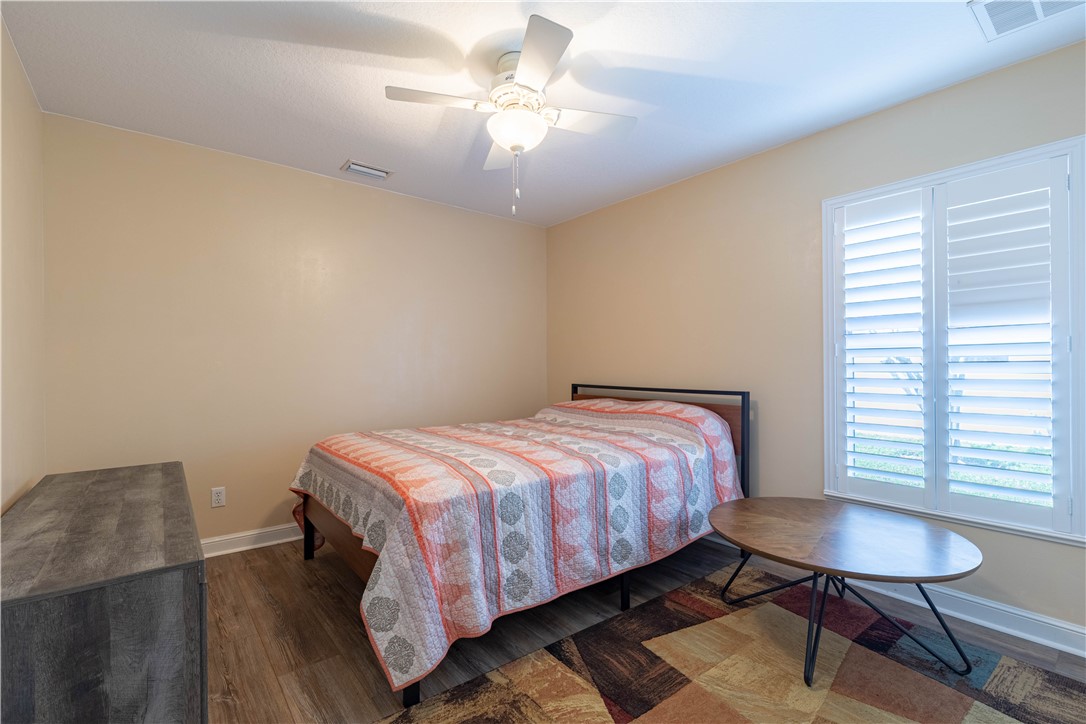 152 35th Square Southwest Vero Beach, FL 32968 - Photo 20 of 35 a bedroom with a bed a chandelier and a window