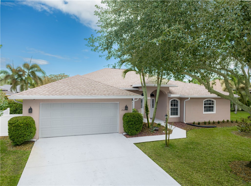 152 35th Square Southwest Vero Beach, FL 32968 - Photo 2 of 35 a front view of a house with a garden