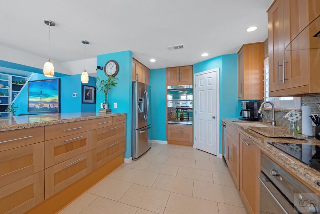 270 Isles End Road Tiki Island, TX 77554 - Photo 14 of 49 a large kitchen with stainless steel appliances lots of counter space and wooden floor