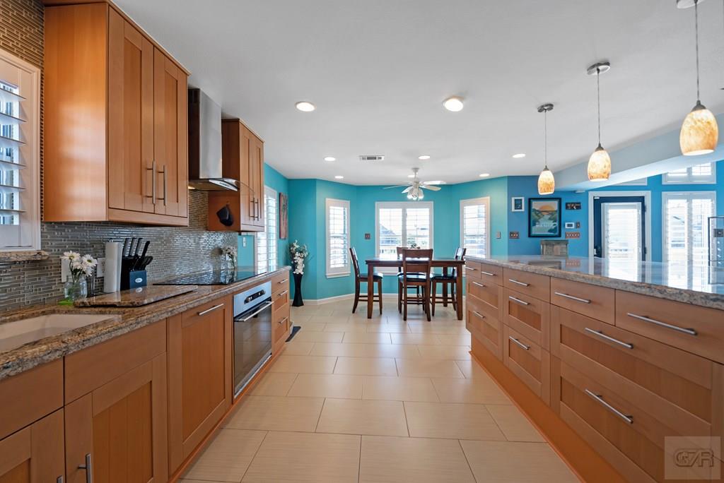 270 Isles End Road Tiki Island, TX 77554 - Photo 15 of 49 a kitchen with stainless steel appliances granite countertop dining table chairs and view living room