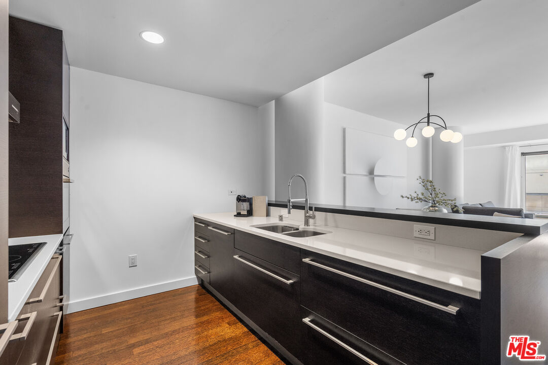 6250 Hollywood Boulevard, Unit 7K Los Angeles, CA 90028 - Photo 15 of 50 a kitchen with a sink stainless steel appliances and wooden floor
