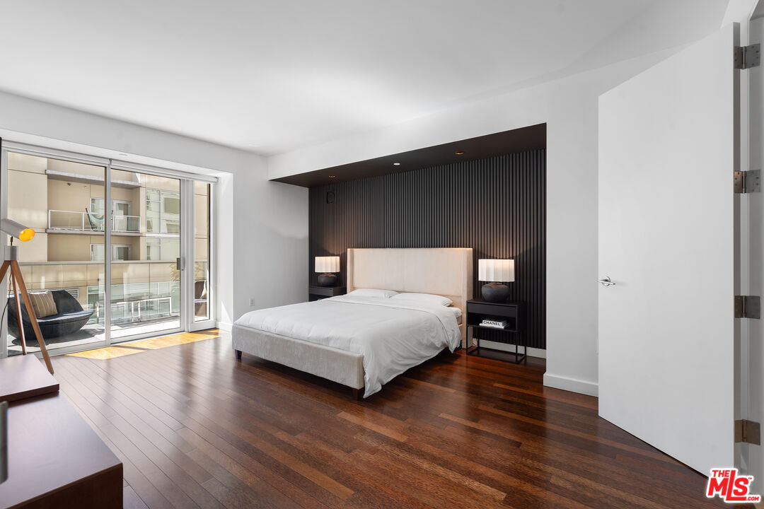 6250 Hollywood Boulevard, Unit 7K Los Angeles, CA 90028 - Photo 18 of 50 a bedroom with a bed and glass door
