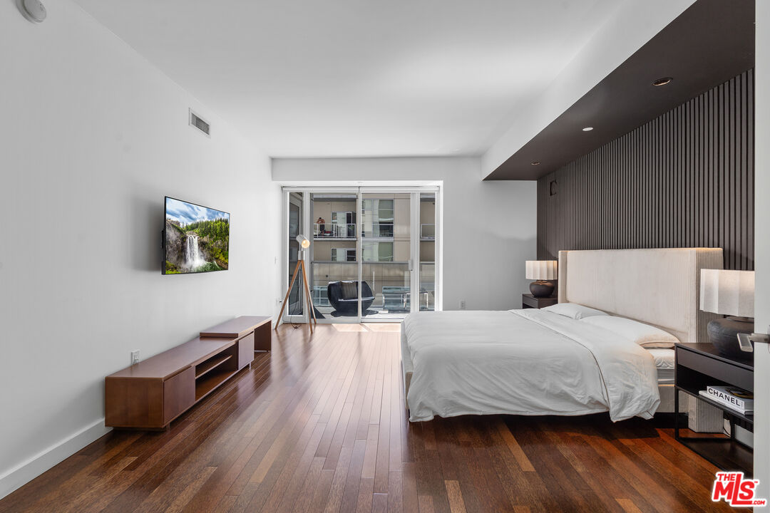 6250 Hollywood Boulevard, Unit 7K Los Angeles, CA 90028 - Photo 20 of 50 a bedroom with a bed and wooden floor