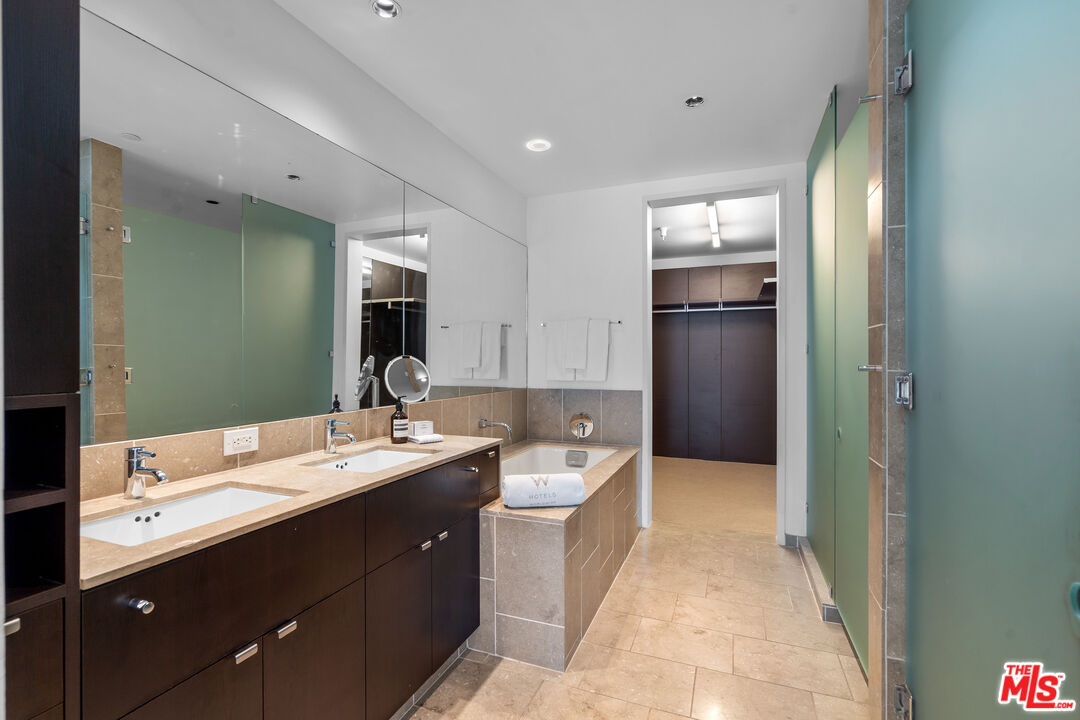 6250 Hollywood Boulevard, Unit 7K Los Angeles, CA 90028 - Photo 24 of 50 a en suite bathroom with a double vanity sink a large mirror and a bathtub