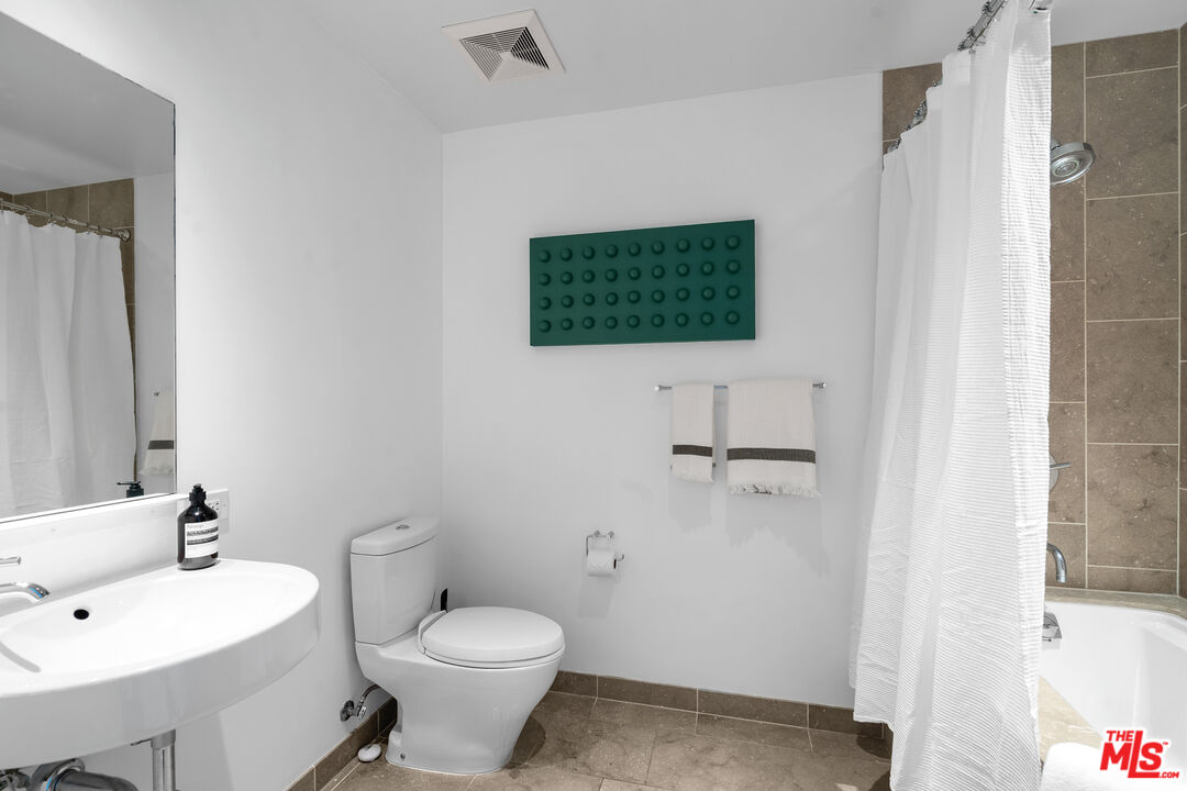 6250 Hollywood Boulevard, Unit 7K Los Angeles, CA 90028 - Photo 28 of 50 a bathroom with a toilet sink and mirror