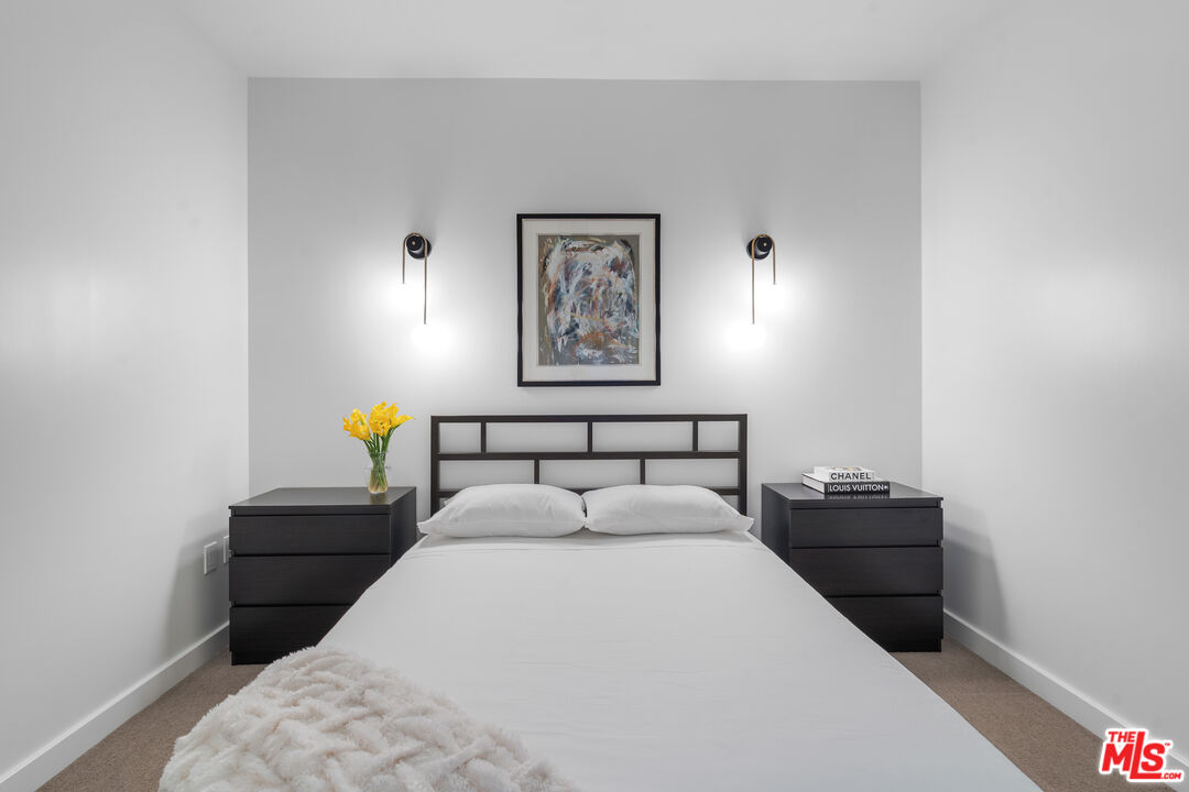 6250 Hollywood Boulevard, Unit 7K Los Angeles, CA 90028 - Photo 29 of 50 a bed sitting in a bedroom and a wooden floor