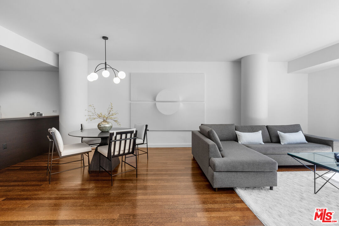 6250 Hollywood Boulevard, Unit 7K Los Angeles, CA 90028 - Photo 4 of 50 a living room with couches chairs and kitchen view with wooden floor