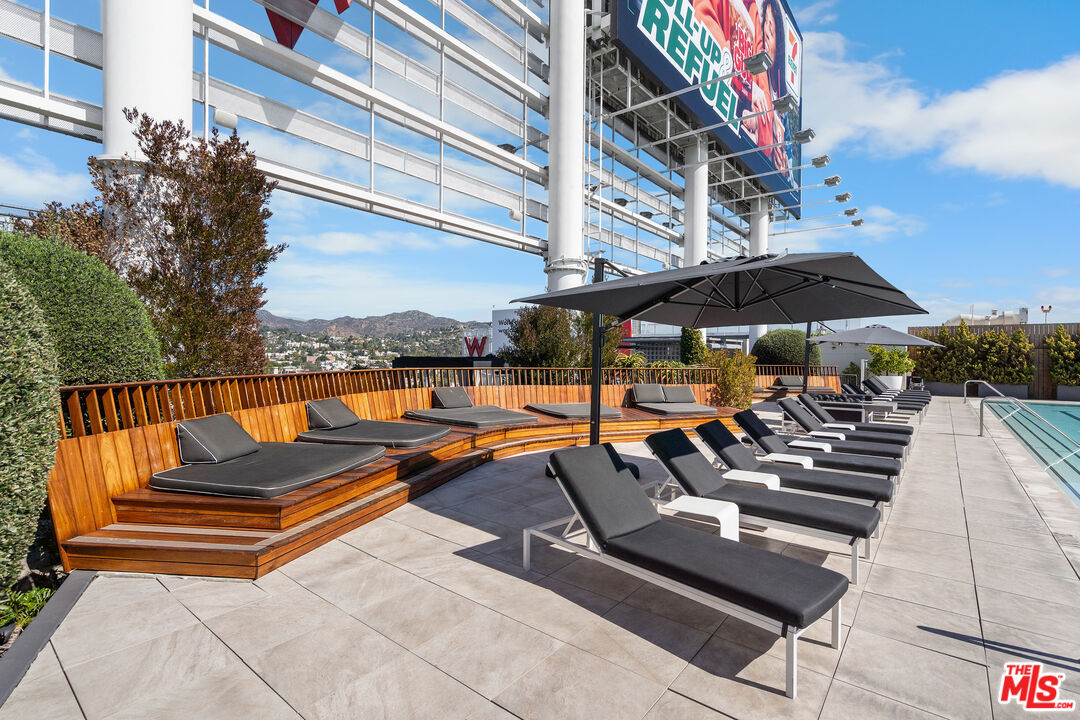 6250 Hollywood Boulevard, Unit 7K Los Angeles, CA 90028 - Photo 42 of 50 a view of patio with chairs and table under an umbrella with a barbeque