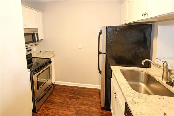 a kitchen with granite countertop a sink and a stove top oven