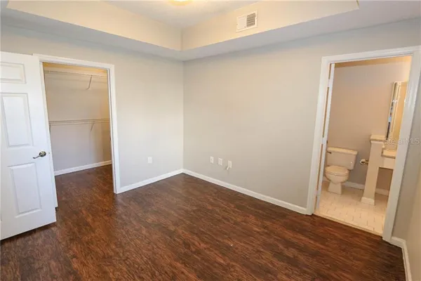 an empty room with wooden floor and entrance