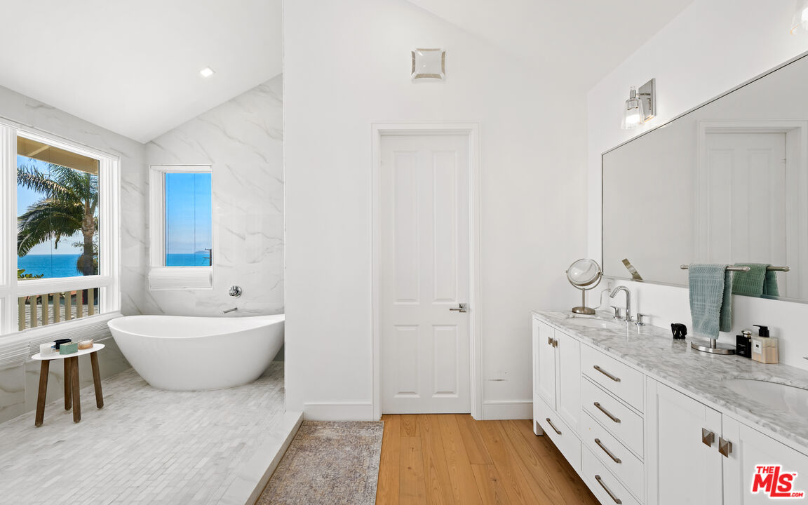 25157 Malibu Road Malibu, CA 90265 - Photo 15 of 33 a spacious bathroom with a double vanity sink a mirror and a bathtub