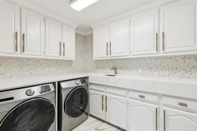 a utility room with sink dryer and washer