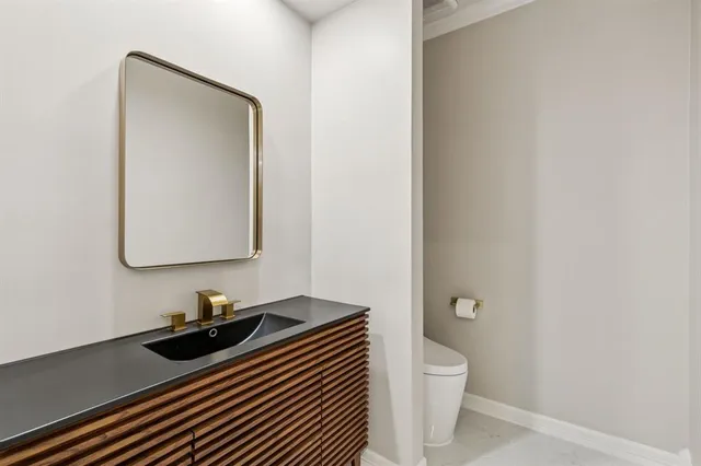 a bathroom with a toilet a sink and mirror