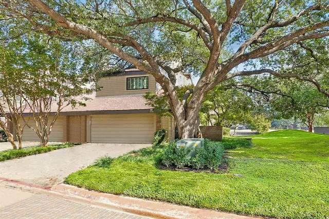 a front view of a house with yard and green space