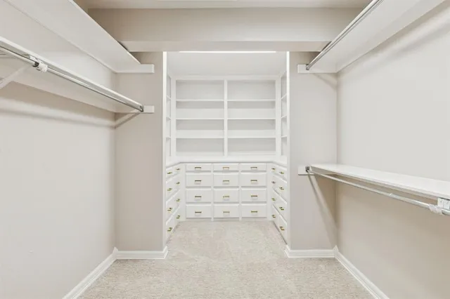 a view of walk in closet with empty racks