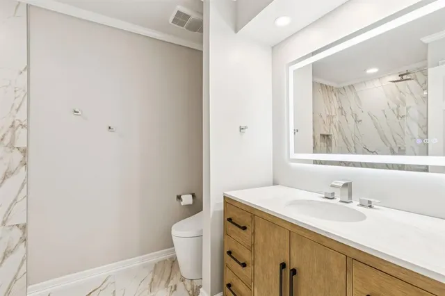 a bathroom with a sink toilet and a mirror