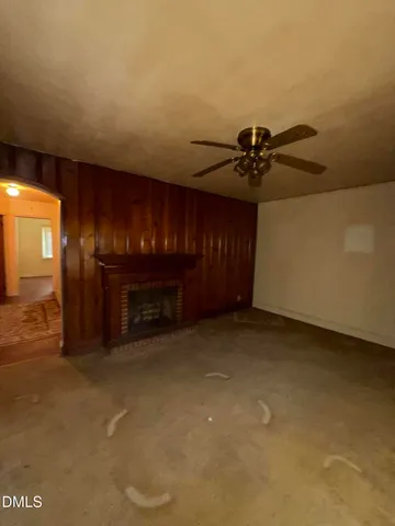 a view of an empty room with a fireplace and a chandelier