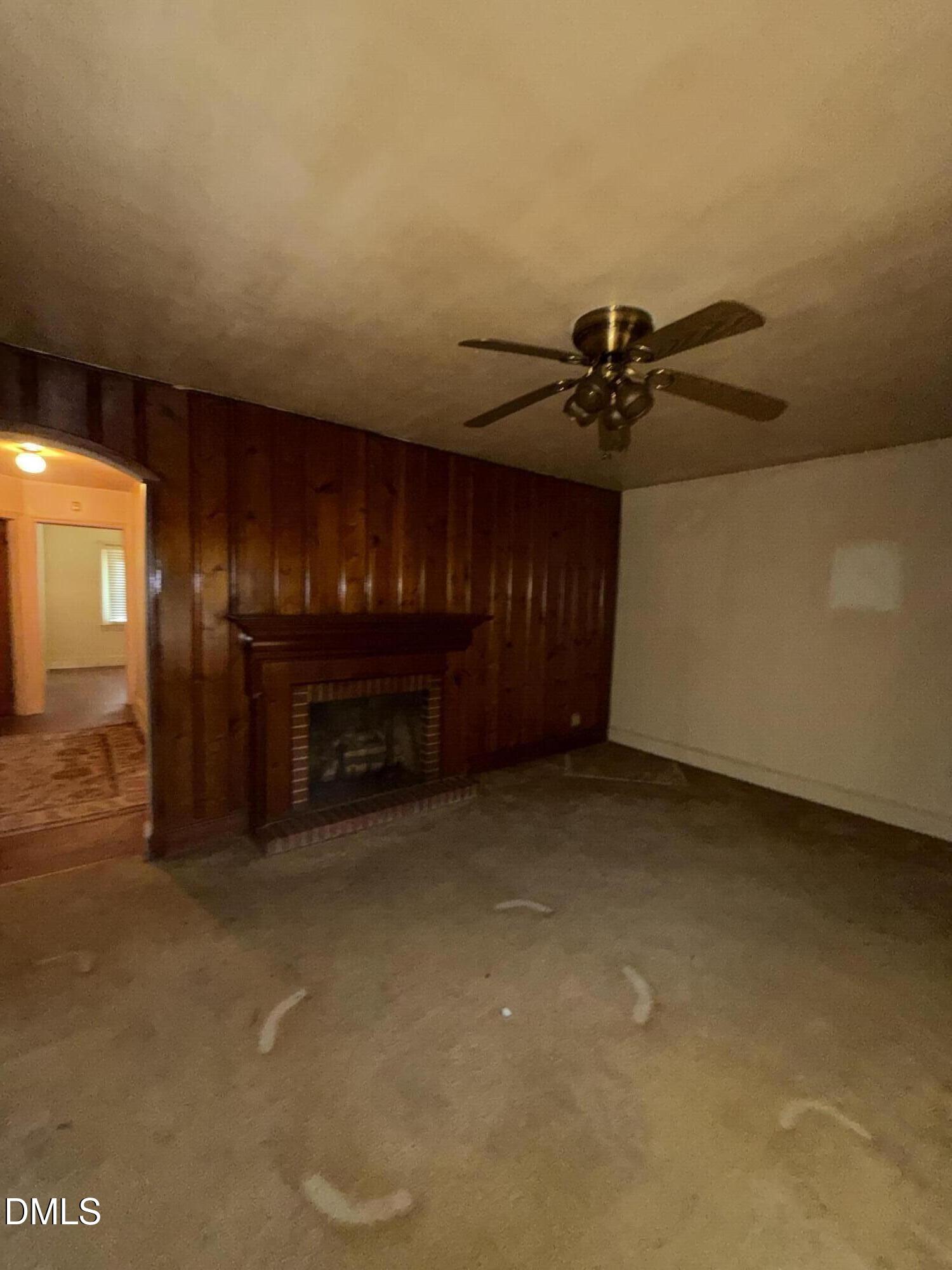 404 Forbes Drive Smithfield, NC 27577 - Photo 5 of 11 a view of an empty room with a fireplace and a chandelier