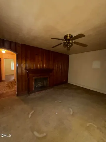 a view of an empty room with a fireplace and a chandelier