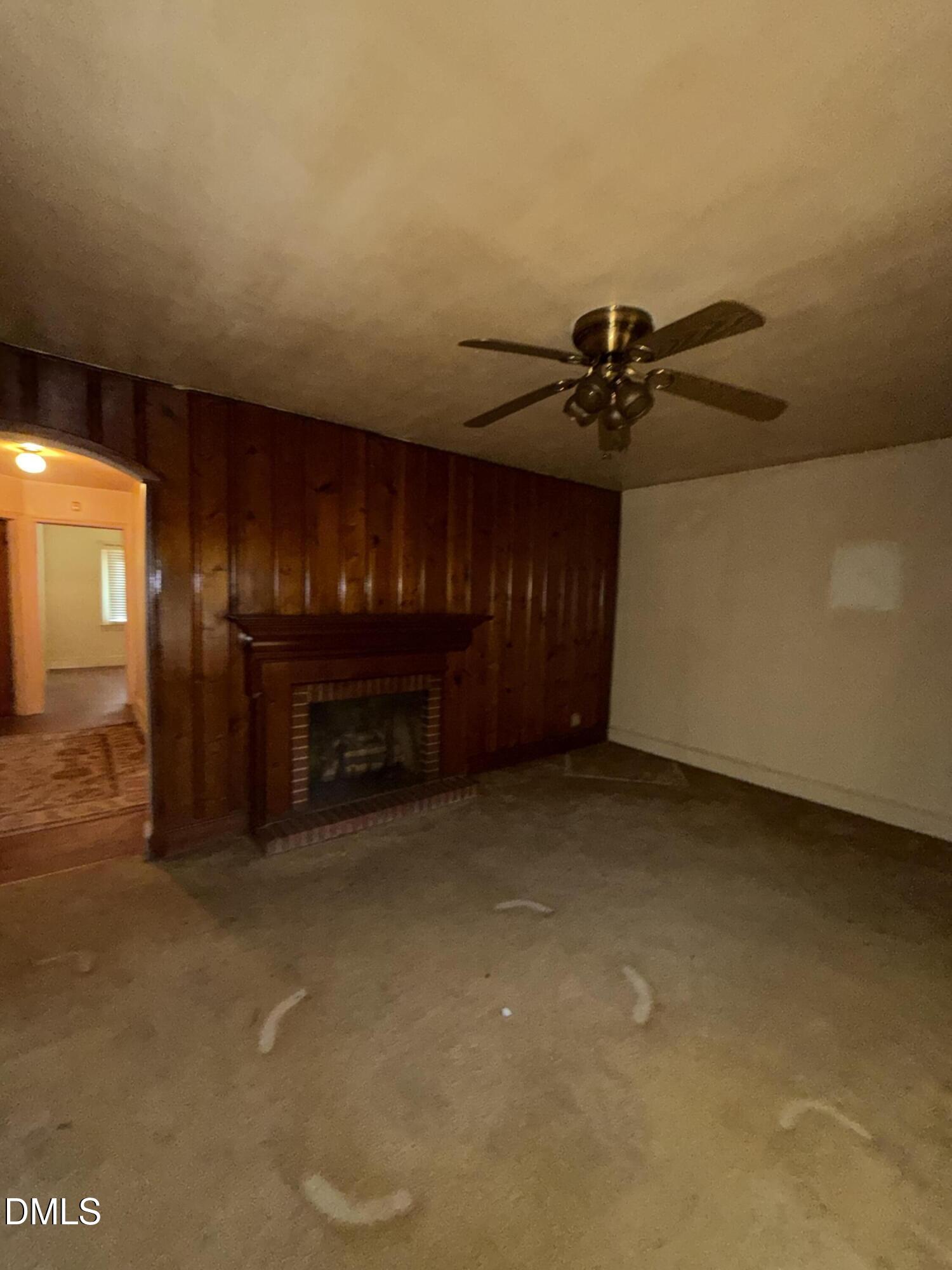 404 Forbes Drive Smithfield, NC 27577 - Photo 6 of 11 a view of an empty room with a fireplace and a chandelier