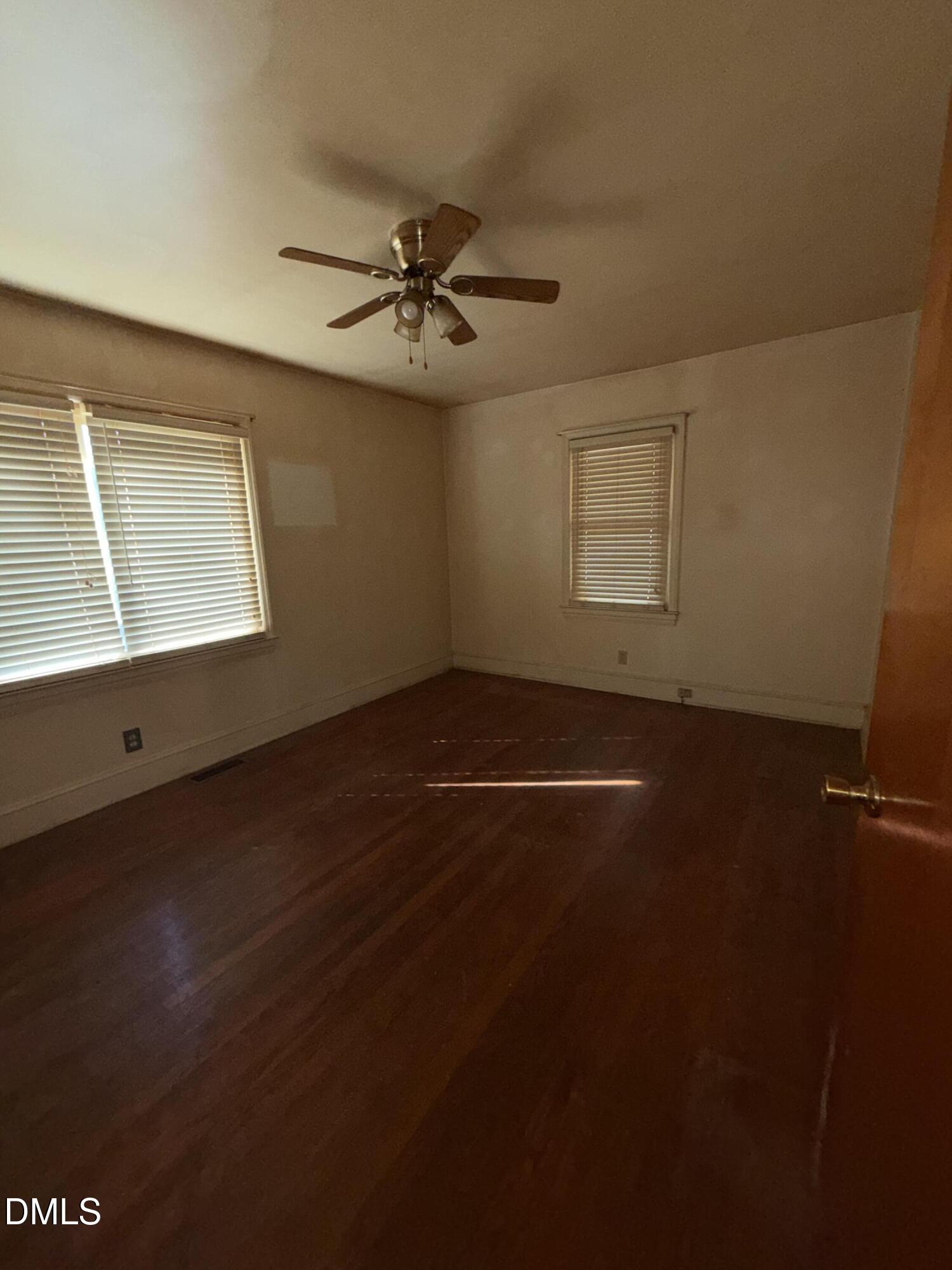404 Forbes Drive Smithfield, NC 27577 - Photo 8 of 11 an empty room with wooden floor fan and windows