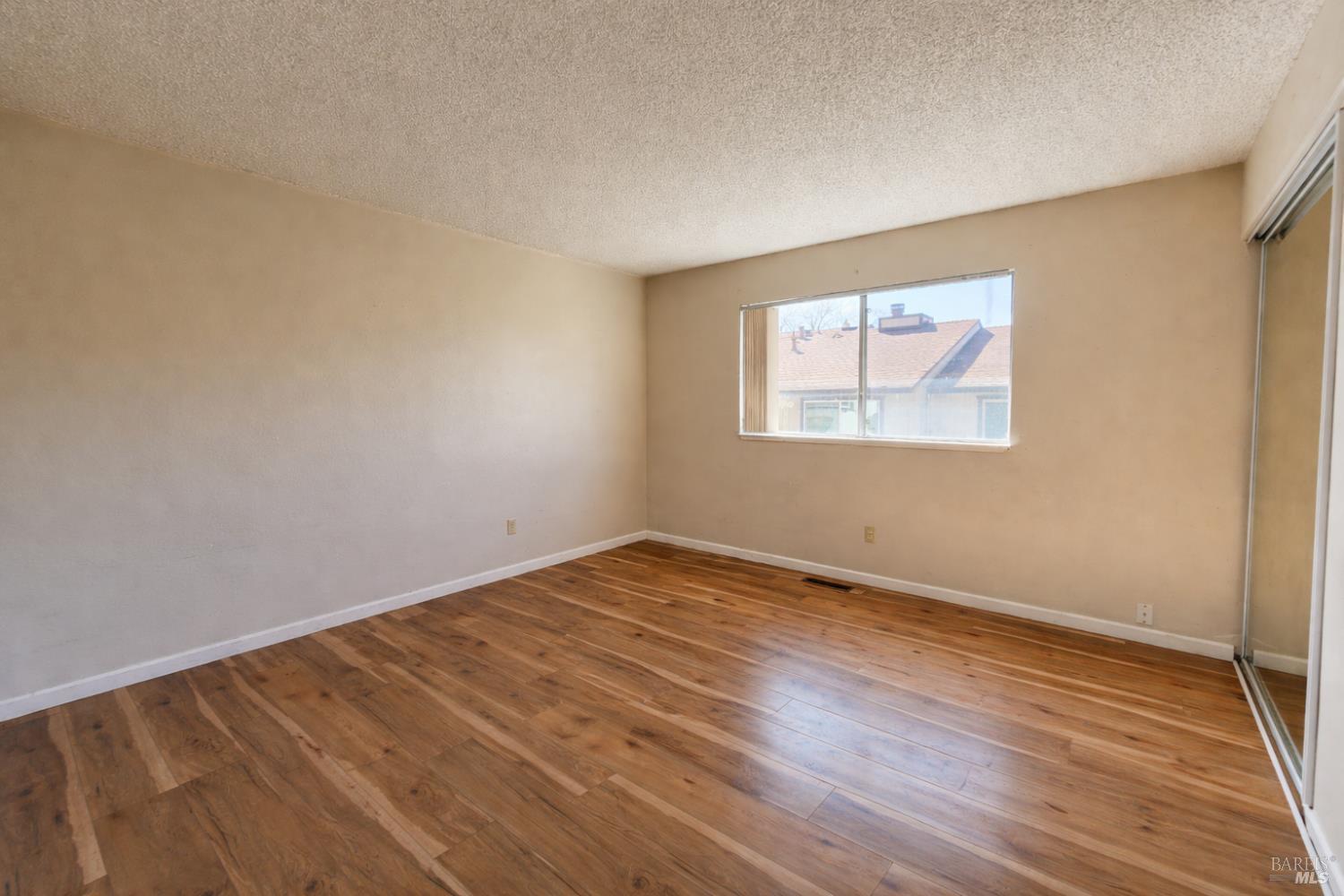 717 Blair Place Santa Rosa, CA 95401 - Photo 13 of 23 an empty room with wooden floor and windows