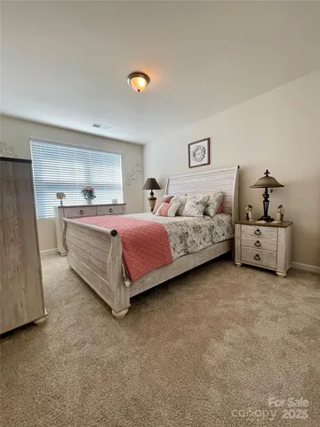 a spacious bedroom with a bed and a lamp