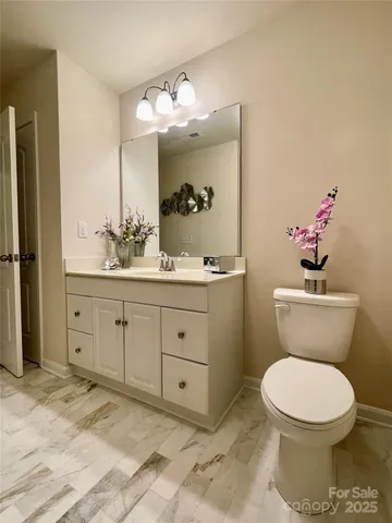 a bathroom with a toilet a sink and mirror