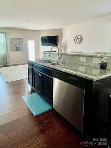 a kitchen with kitchen island granite countertop a sink and a stove