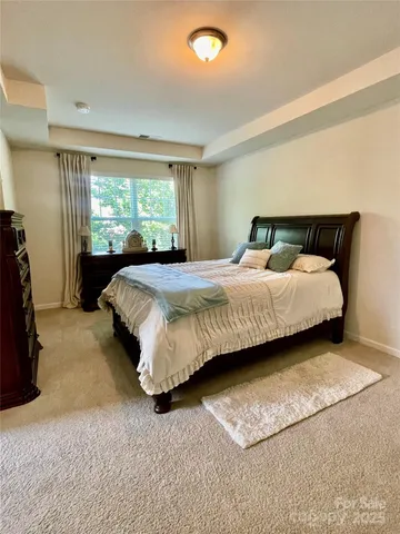 a bedroom with a bed lamp and a large window