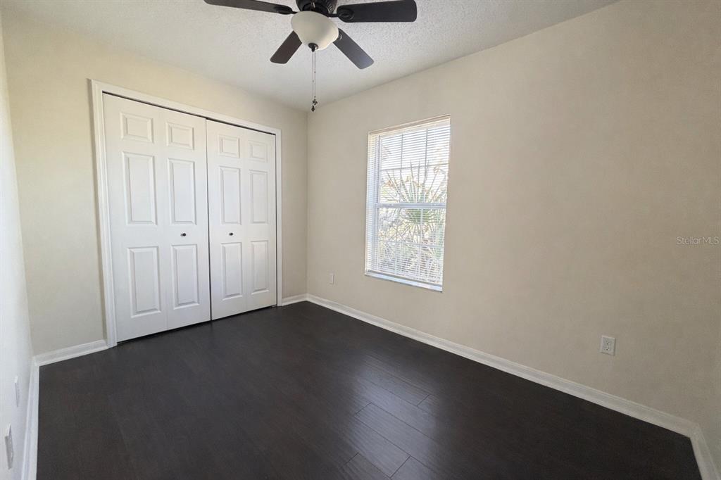 16 Powder Hill Lane Palm Coast, FL 32164 - Photo 11 of 27 an empty room with wooden floor chandelier fan and windows