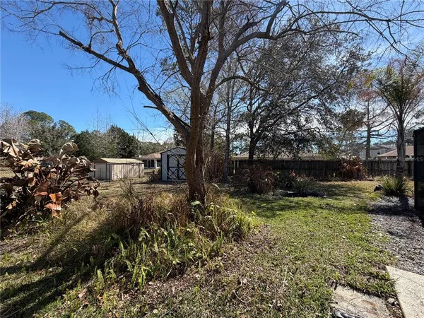 a view of a backyard with wooden fence